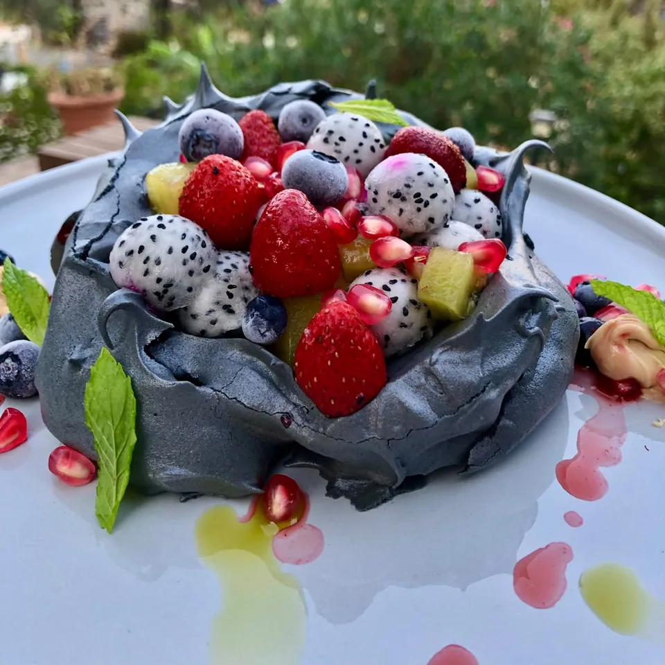 Charcoal pavlova with berries and dragon fruit