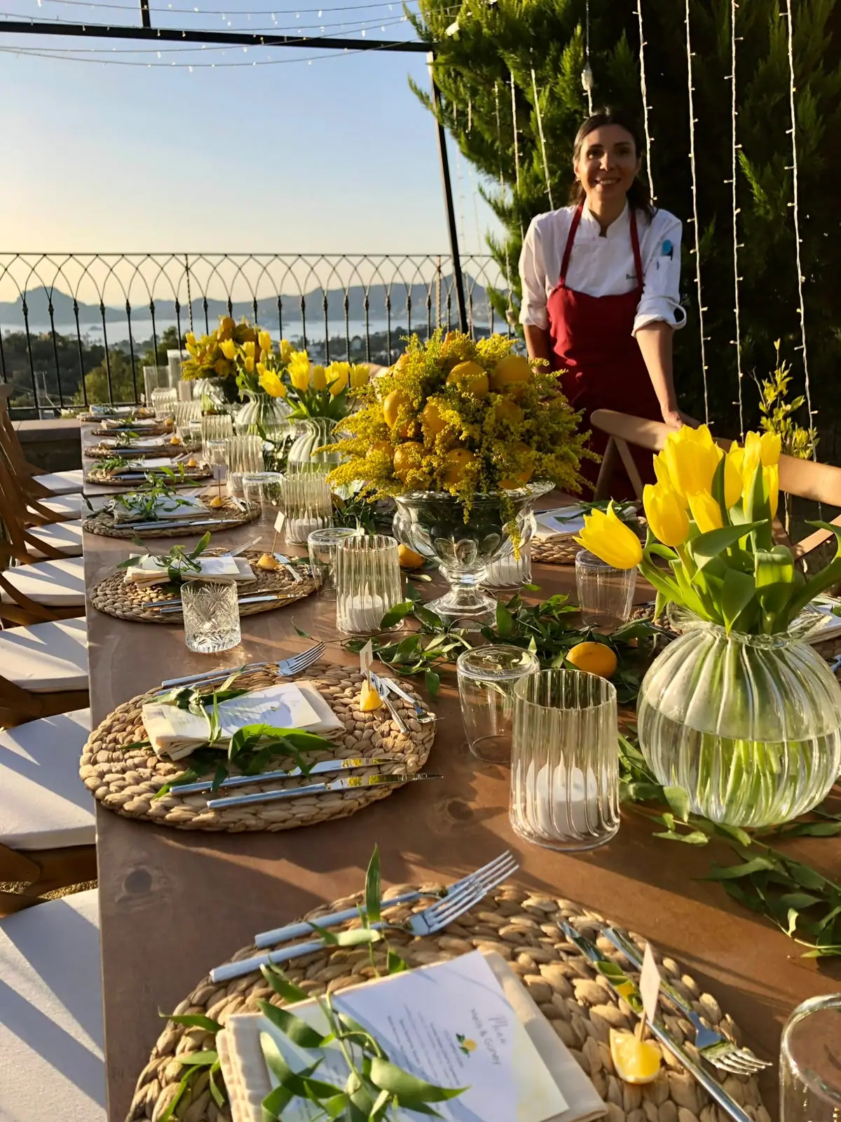 Long table with yellow tulips on a sea view terrace, chef Birnur