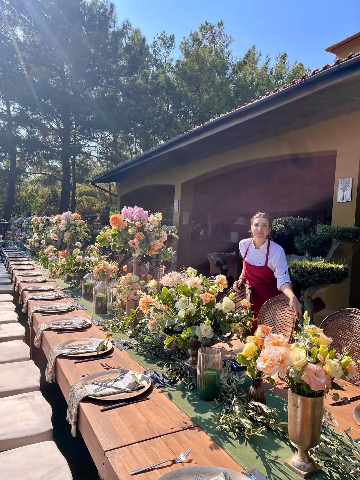 Long garden table with floral arrangements and chef Birnur
