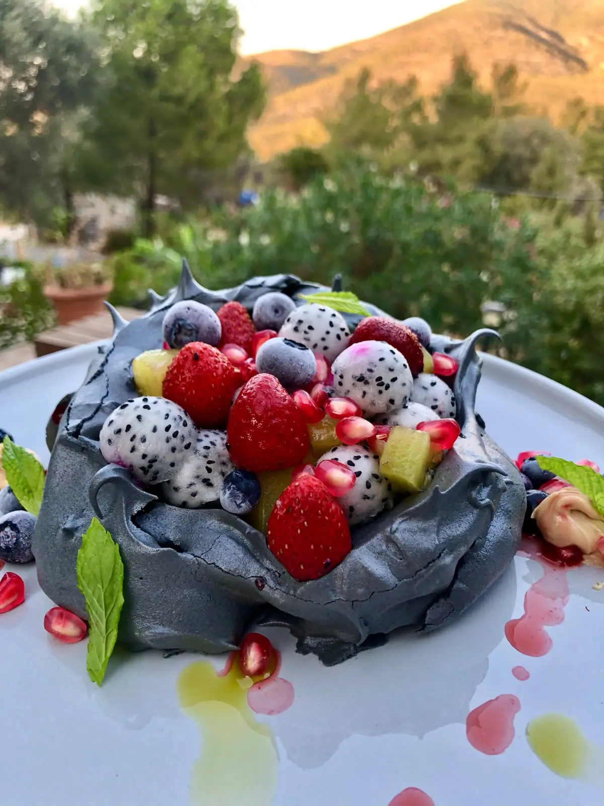 Charcoal pavlova with berries and dragon fruit